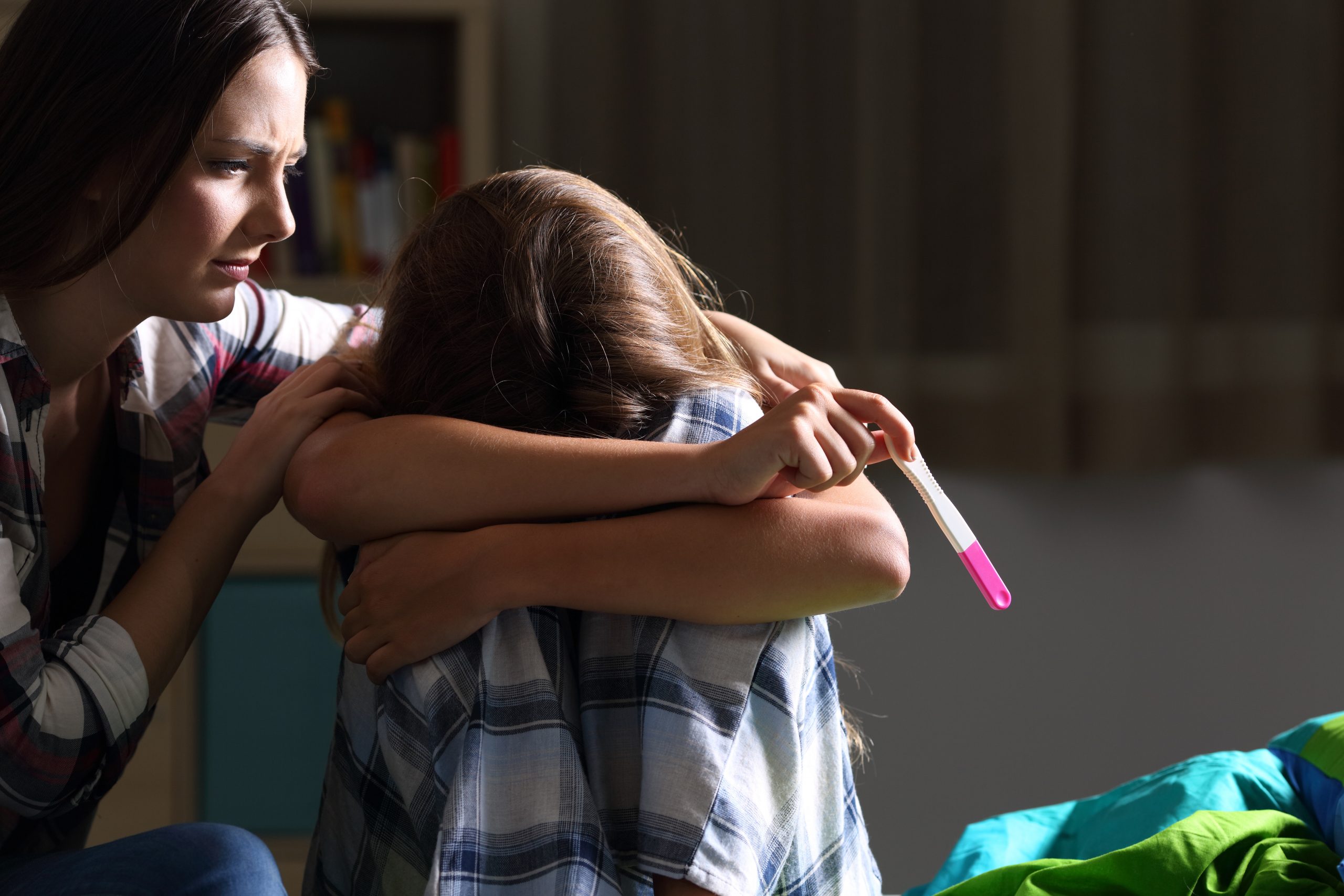 Sister comforting to a pregnant sad teen